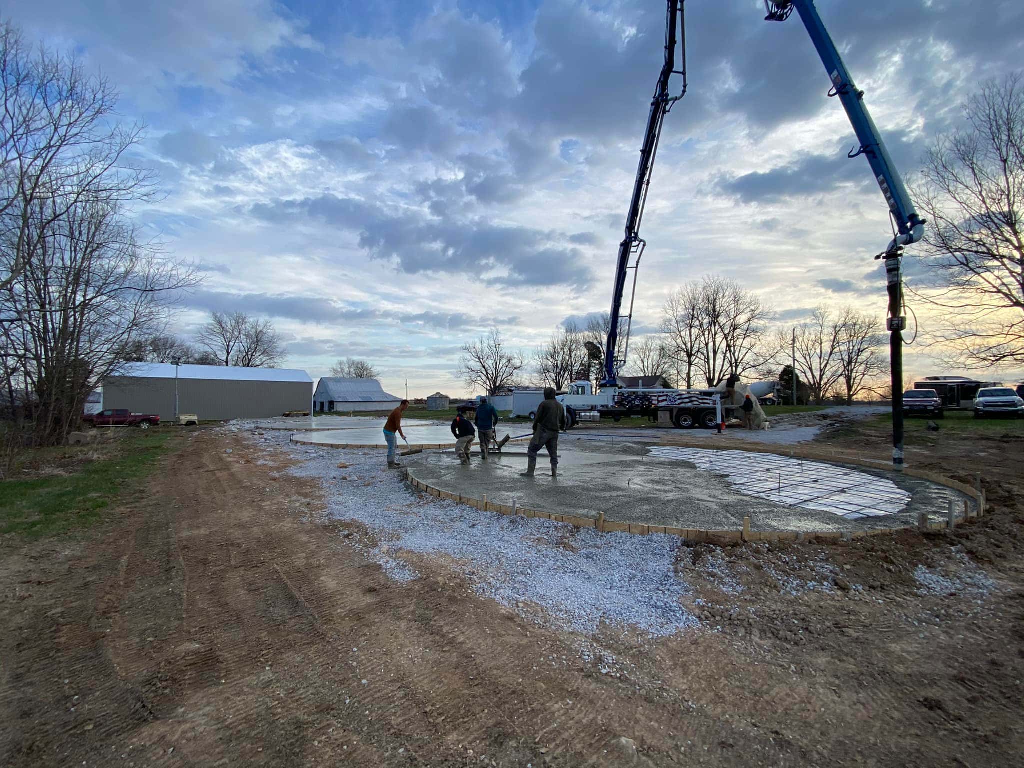 Concrete pump truck and crew placing a large slab on a prepared gravel base in Western Kentucky