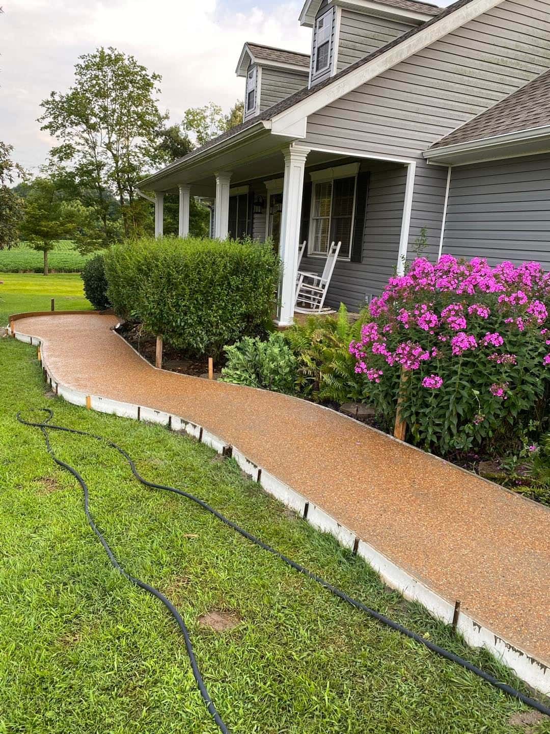 Exposed-aggregate concrete walkway curving alongside a home in the Paducah, KY area